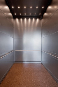 FSRT747 Внутренняя часть лифта Levele-104 с панелями из нержавеющей стали с отделкой из песчаника, нержавеющей стали с отделкой из песчаника и нестандартным круговым оттиском; круглые поручни в магазине world of coca-cola, атланта, грузия Forms-surfaces 